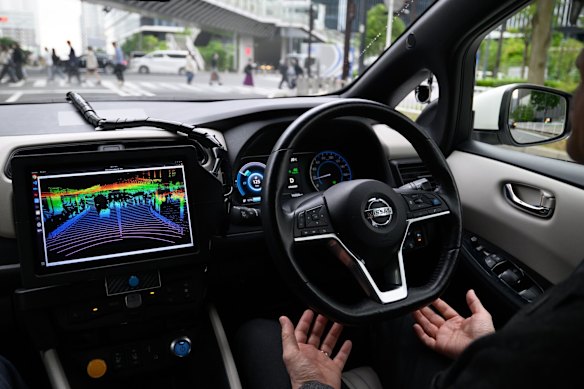 A driver takes their hands off the wheel of a Nissan Leaf electric vehicle equipped with autonomous driving technology during a test ride in the Yokohama, Japan.