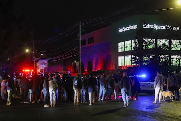 People gather outside a storage facility where a suspect in the Brown University shooting was found dead.