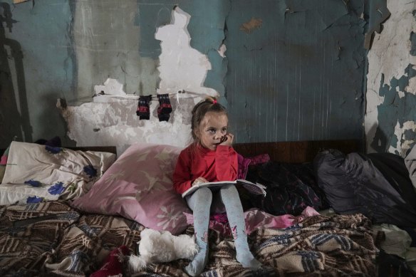 A girl sits in an improvised bomb shelter in Mariupol, Ukraine.