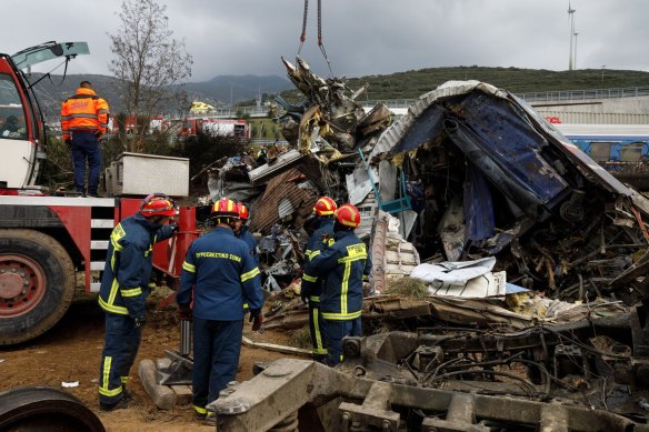 Rescue workers at the site of a derailed passenger train following the collision in the Tempe valley near Larissa, Greece.