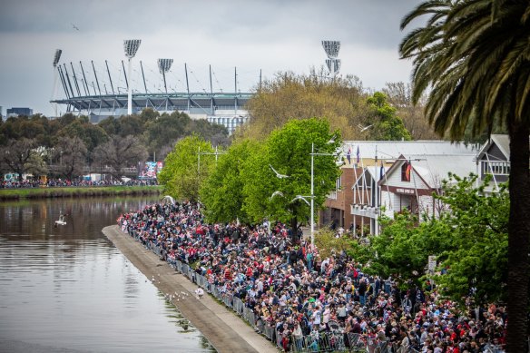 Crowds flocked to the banks of the Yarra River to see the AFL grand final players on boats last year - but many  needed binoculars to get a proper glimpse.