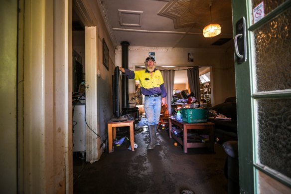 The flood has devastated the town of Rochester. Here, Mick Hassell cleans up his home, which was inundated.