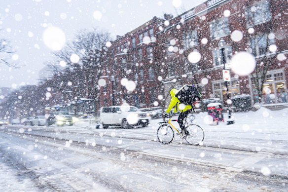A delivery worker rides a bike during the storm.