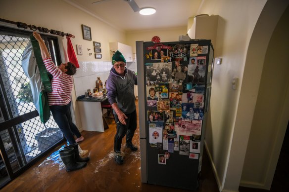 Water sloshes around the Mulcahys’ feet as they prepare their home for the flood.