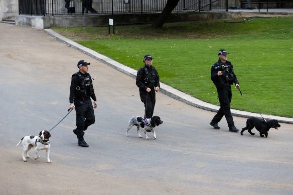 Police officers with sniffer dogs prepare ahead of the state funeral of Queen Elizabeth II.