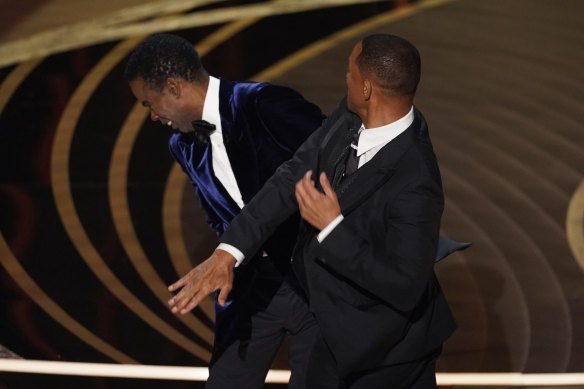 Will Smith, right, hits presenter Chris Rock on stage.