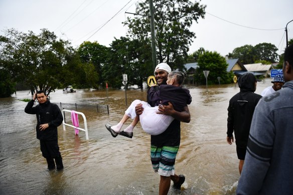 A woman is carried to safety after Fromelles Manor flooded on February 28. 