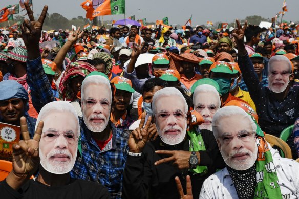 Bharatiya Janata Party (BJP) supporters wear masks of Prime Minister Narendra Modi at a rally in 2021.
