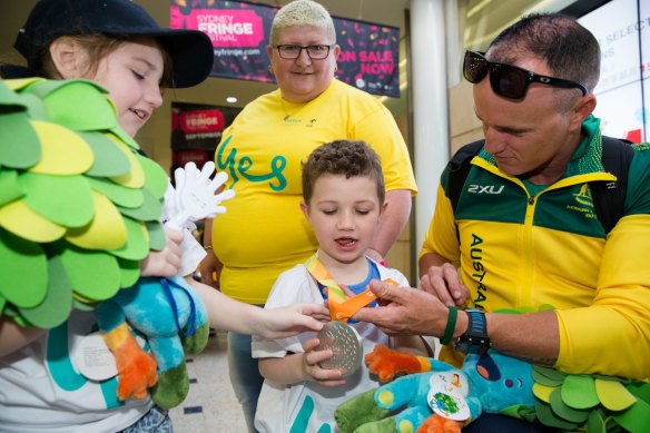 Erik Horrie is greeted by his family, Michelle Brown and kids, Summer and Lewis, after arriving back in Sydney from the Rio Paralympics in 2016.
