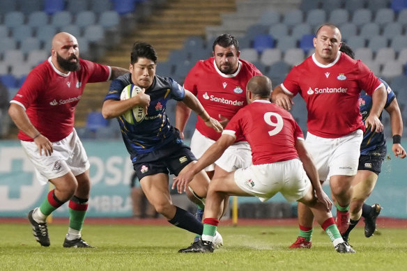 Portugal players, in red jerseys, taking on Japan in 2021.