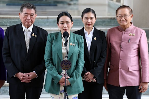 Paetongtarn Shinawatra (segunda esquerda) fala com a mídia após sua suspensão do cargo.