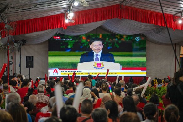 Attendees watch a broadcast of the swearing-in ceremony of Prime Minister Lawrence Wong in Singapore, on Wednesday evening.