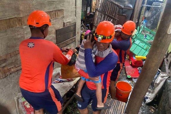 Rescuers evacuate residents in Batangas province on Sunday.
