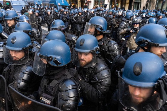 Riot police guard the Constitutional Council building during a demonstration against pension reform in central Paris on Thursday.