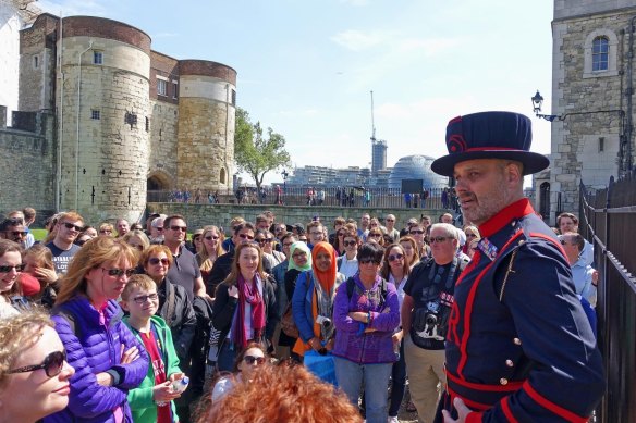 Tourists with a Beefeater at the Tower of London. 