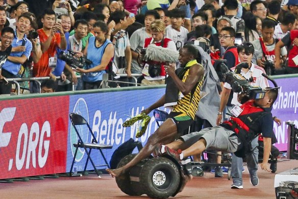 Usian Bolt is hit by a cameraman on a Segway as he celebrates winning the men's 200 metres final at the World Championships in Beijing.