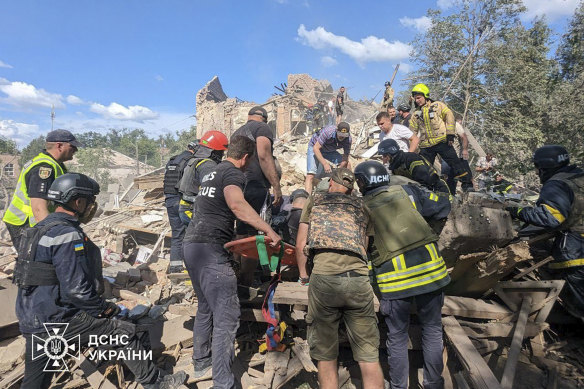 Ukrainian emergency workers clear the rubble as they search for victims after a Russian missile struck.