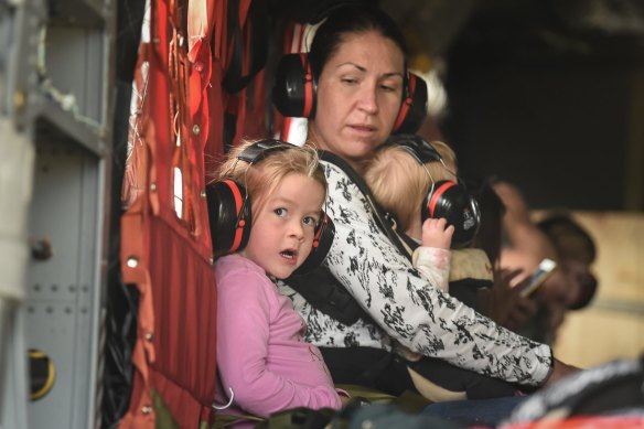 A family evacuating on board a Chinook Helicopter.
