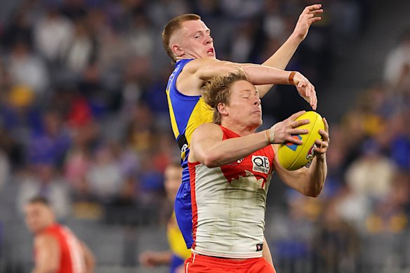 Isaac Heeney of the Swans marks the ball against Luca Grego of the Eagles.