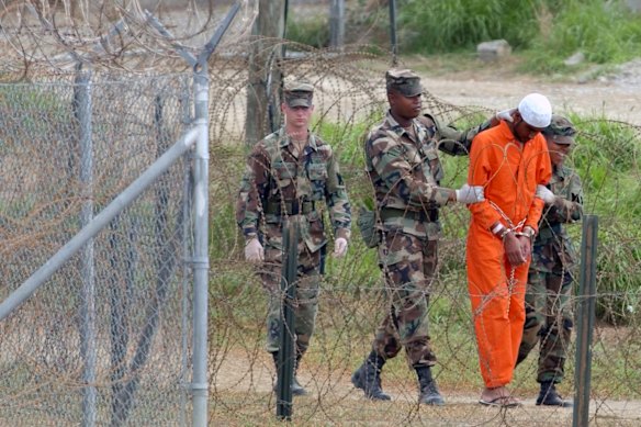 Un detenuto viene spostato dalle guardie carcerarie a Guantánamo nel 2002. Oggi vi rimangono solo 15 detenuti.