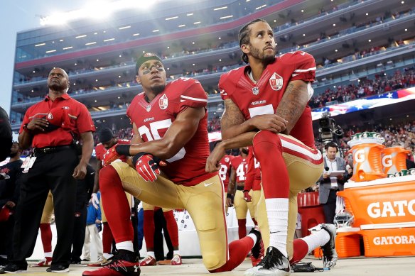 Colin Kaepernick, right, takes a knee during the US national anthem at an NFL game in 2016.