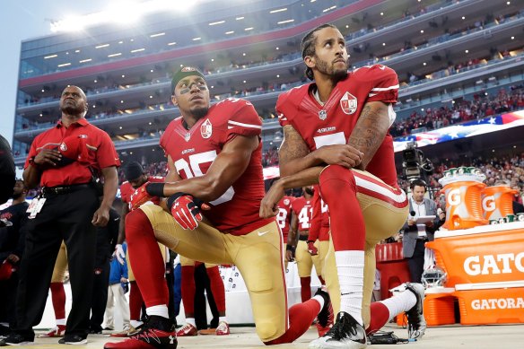 Colin Kaepernick, right, and Eric Reid take a knee during the US national anthem in 2016.