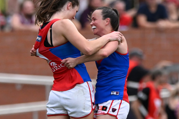 Melbourne captain Daisy Pearce (right) celebrates the Demons’ AFLW flag with a teammate.