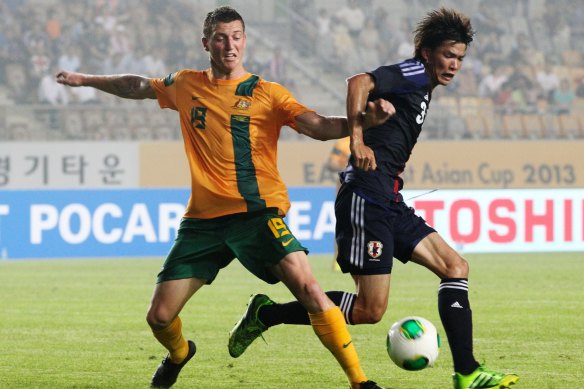 Mitch Duke fights for the ball against Japan’s Masato Ogihara during their men’s East Asian Cup match back in mid-2013.