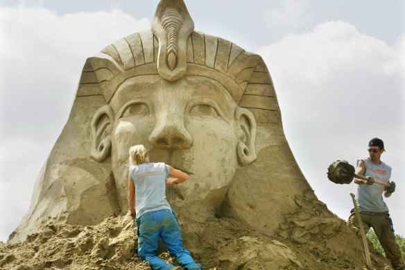 Marlies Bielderman  and Anael Beauregard carve the Sphinx of Giza into the sand at a sculpting festival in northern Germany.
