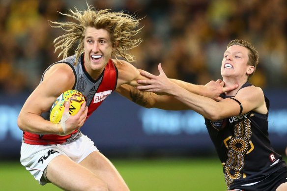 Dyson Heppell fends off a tackle by Connor Menadue in 2015.