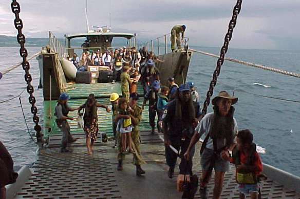 Australians and foreign nationals are assisted onto the HMAS Tobruk after being evacuated from the Solomon Islands.