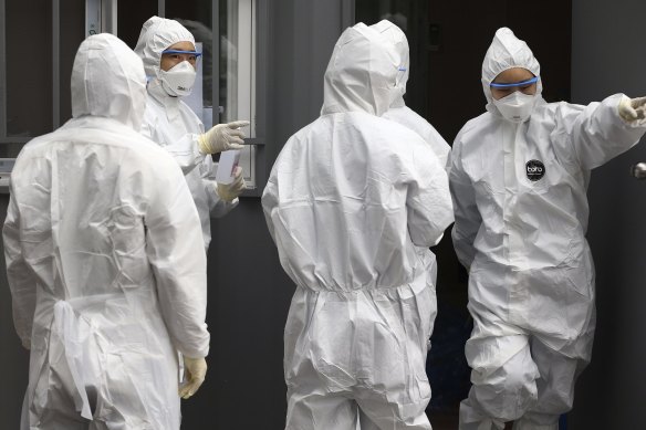 Officials wearing protective attire work to diagnose people with suspected symptoms of the new coronavirus at a hospital in Daegu, South Korea.