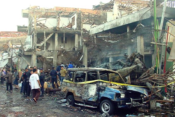 Police officers inspect the ruins of a nightclub destroyed by an explosion in Bali in October 2002.  
