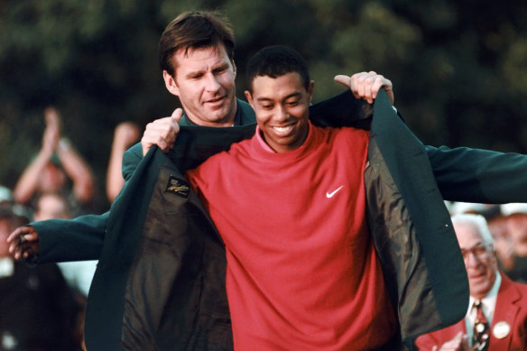 Nick Faldo presents Tiger Woods with his first green jacket in 1997.