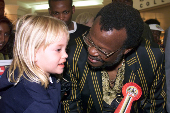 Mangosuthu Buthulezi greets four-year-old Samantha Briscoe while touring a shopping centre in Durban in 1999.