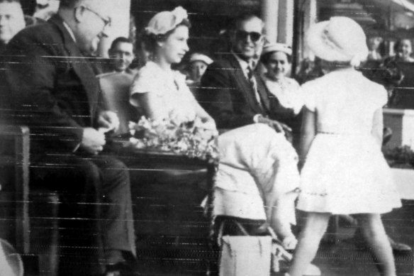 Narelle Dick, 4, approaches the Queen after eluding security guards and tries to kiss her, as the Duke of Edinburgh smiles during a Children’s Rally at the Show Grounds in Brisbane 1954.