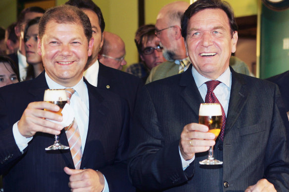 Then-German Chancellor Gerhard Schroeder, right, drinking a glass of beer with then-Social Democratic member of German parliament, and future Chancellor Olaf Scholz during their visit to the Holsten brewery in Hamburg in 2005.
