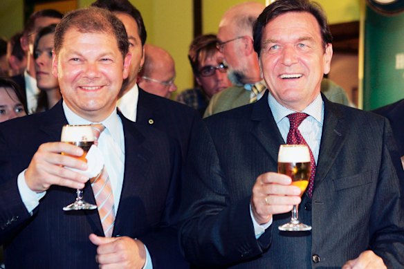 Then-German Chancellor Gerhard Schroeder, right, drinking a glass of beer with then-Social Democratic member of German parliament, and future Chancellor Olaf Scholz during their visit to the Holsten brewery in Hamburg in 2005.