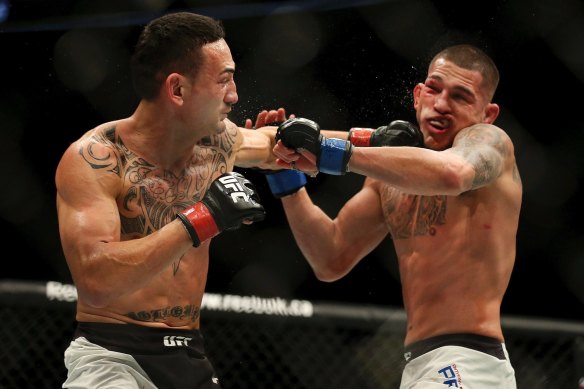 Max Holloway, left, punches Anthony Pettis in an interim featherweight title during UFC 206. 