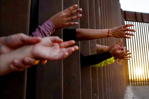 Immigrants reach for soup donated by the Yuma County Abolition group after crossing the border from Mexico in San Luis, Arizona. 