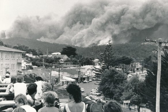 People on the balcony of Lorne Hotel watch as fire rolls over the Otway Ranges towards Lorne.