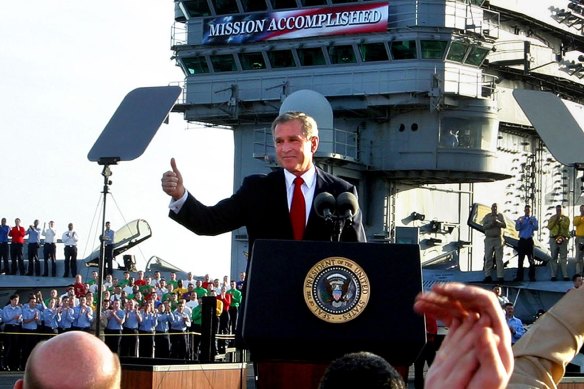 President Bush flashes a “thumbs-up” after declaring the end of major combat in Iraq in May 2003. The country would be convulsed by violence for years afterward.