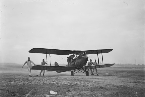 Men pushing Captain Matthews' plane on his arrival at Mascot Aerodrome, Sydney, October 27, 1930.