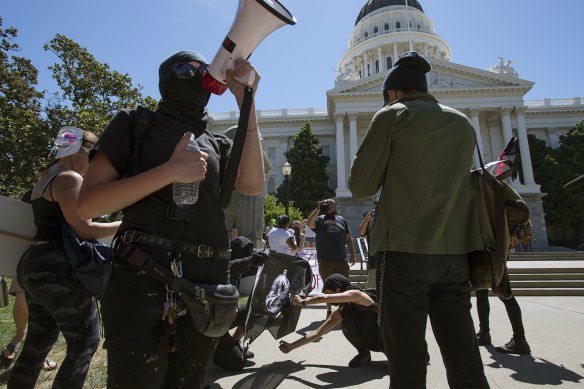 Members of the group called Antifa Sacramento try to light a flag on fire as they stage a counter-protest against skinheads at the California state Capitol in 2016.