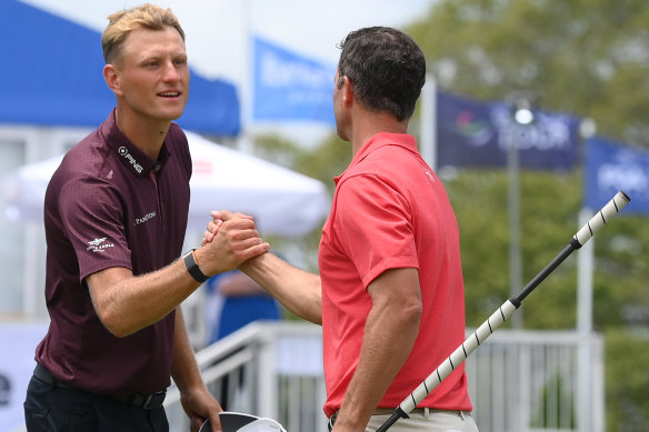 Adam Scott (right) and Adrian Meronk of Poland shake hands after finishing day one.
