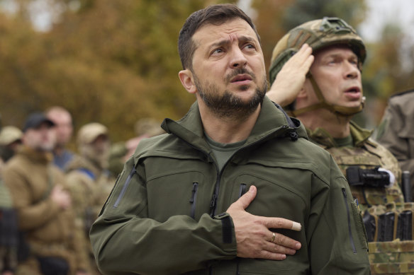 Ukrainian President Volodymyr Zelensky sings the Ukrainian national anthem during his visit to the city of Izium.