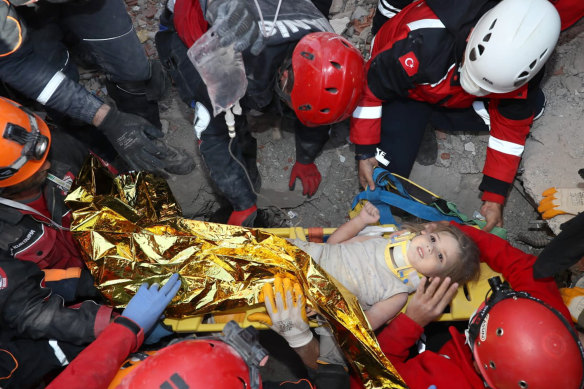 Ayda Gezgin being taken into an ambulance on Tuesday, wrapped in a thermal blanket, amid the sound of cheers and applause from rescue workers.