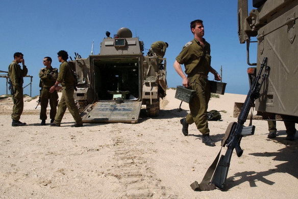 Israeli soldiers prepare their armoured personnel carriers at Kibbutz Be’eri in southern Israel near the border with  the Gaza Strip.