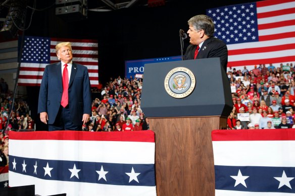 Then-US president Donald Trump watches Fox News’ Sean Hannity speak at a Trump rally in 2018.