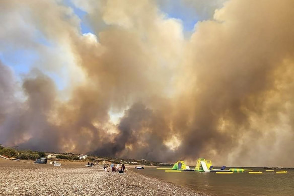 Clouds of smoke from a forest fire rise in the sky on the island of Rhodes, Greece.